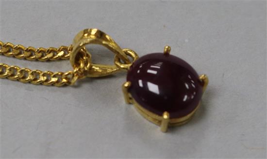 A yellow metal and cabochon ruby set pendant on a 22ct gold chain.